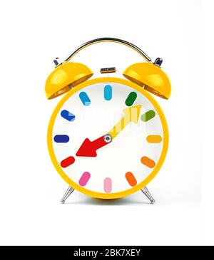 Close up one vivid yellow retro alarm clock with twin metal bells isolated on white background, low angle front view Stock Photo