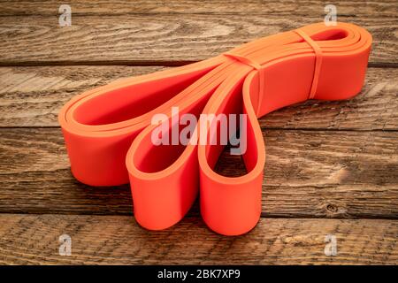 resistance exercise band for fitness and rehabilitation against wooden background Stock Photo