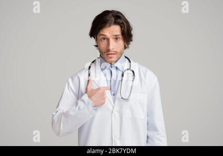 Puzzled male therapist pointing at himself with questionnaire face expression Stock Photo