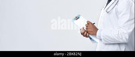 Cropped of black doc filling medical form Stock Photo