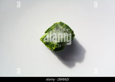 A cube of frozen spinach on white background Stock Photo