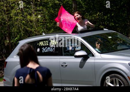 Potomac, United States. 02nd May, 2020. A friend congratulates Sami Snow (foreground) during a surprise drive-by Bat Mitzvah celebration in Potomac, Maryland on Saturday, May 2, 2020. The family held a small ceremony at the home with the Rabbi officiating online followed by a surprise drive by Mitzvah celebration due to the Coronavirus (COVID-19) social-distancing requirements. Photo by Kevin Dietsch/UPI Credit: UPI/Alamy Live News Stock Photo