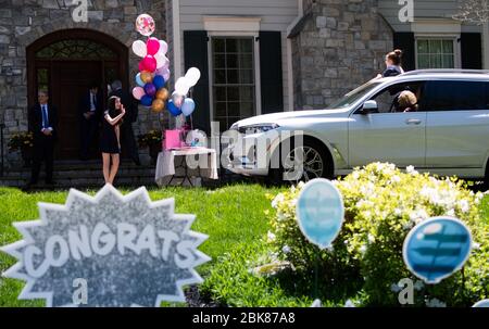 Potomac, United States. 02nd May, 2020. A friend congratulates Sami Snow (left) during a surprise drive-by Bat Mitzvah celebration for her in Potomac, Maryland on Saturday, May 2, 2020. The family held a small ceremony at the home with the Rabbi officiating online followed by a surprise drive by Mitzvah celebration due to the Coronavirus (COVID-19) social-distancing requirements. Photo by Kevin Dietsch/UPI Credit: UPI/Alamy Live News Stock Photo