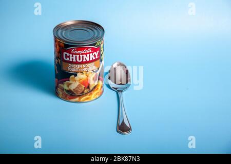 April 11, 2020 - Halifax, Canada: A tin of Campbells brand chicken noodle  soup and a spoon Stock Photo