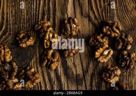 Walnut scattered on the wooden vintage table. Copy space. Walnuts is a healthy vegetarian protein nutritious food. Almonds on rustic old wood. Stock Photo