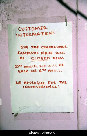 A notice taped to the door of a Nail business informing customers that they are closed because of the Coronavirus outbreak. Stock Photo