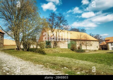 A very old barn in a yard in a sunny idyllic mood Stock Photo