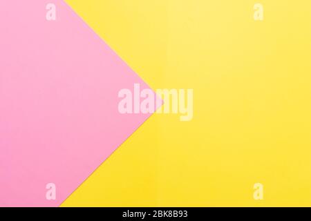 Pink and yellow two colours paper geometrical triangular background. Pink triangle on yellow background Stock Photo