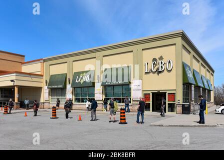Ottawa, Canada - May 2, 2020:  Customers practice social distancing while waiting in line to enter the Liquor Control Board of Ontario (LCBO) store wh Stock Photo