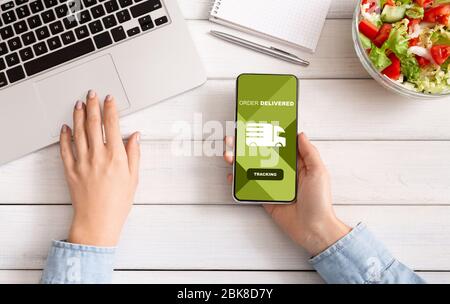 Woman tracking an order using cell phone Stock Photo