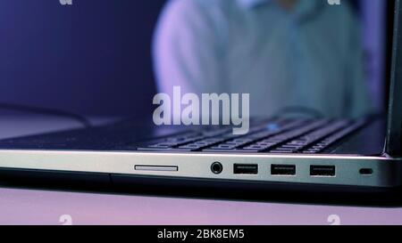 Hands closing laptop computer on table. Close up. Stock Photo