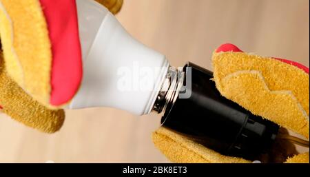 Mans Hands Replacing a Light Bulb in lamp. Close-Up. Stock Photo