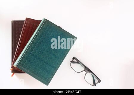 pile of books and glasses isolated on white background Stock Photo