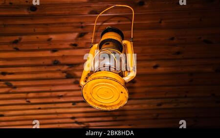 very old, used vintage metal gas light still active, as an ancient rusty object hanging on the ceiling Stock Photo