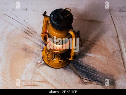 very old, used vintage metal gas light, as an ancient rusty object on the dusty platform Stock Photo