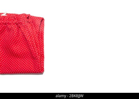 Kid's red with white polka dot pattern pants folded isolated on white background. Stock Photo