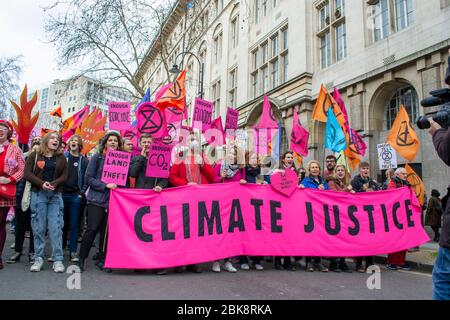 LONDON/ENGLAND – FEBRUARY 22 2020: Extinction Rebellion protesters holding a CLIMATE JUSTICE banner at the February 2020 march Stock Photo