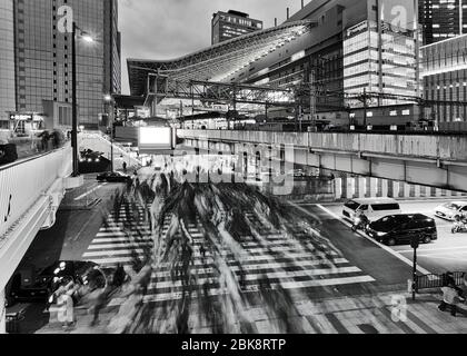 Dark black-white sunset around crowded street crossing in Osaka city near OSaka umeda railway train station. Stock Photo