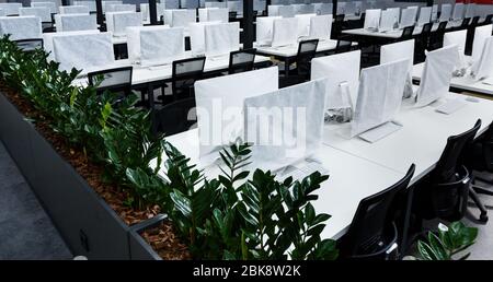 Wrapped in cover computers on workplaces with no people Stock Photo