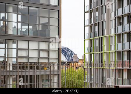 Glimpses of the Sydney Harbour Bridge appear between two tall apartment blocks in the inner Sydney suburb of Pyrmont, Australia Stock Photo