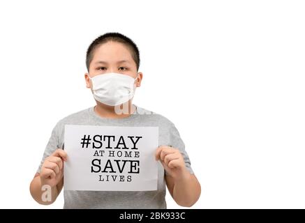 Obese fat boy wear mask shows a paper with stay at home save lives words isolated on white background, Coronavirus, COVID-19, self-quarantine, social Stock Photo