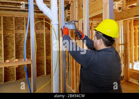 Worker puts on electrical outlets installation in new home Stock Photo