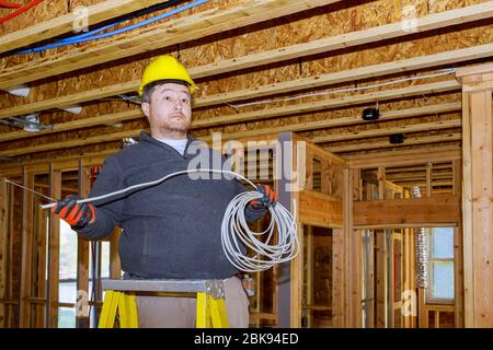 Connecting a new home an electrician works for construction the new building. Stock Photo