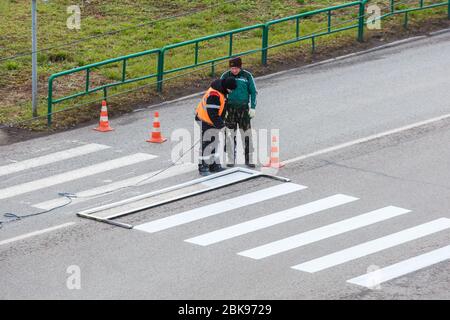 Applying road markings on asphalt using a special machine. Editorial Stock Photo