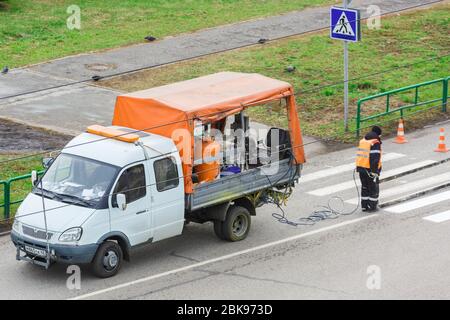 Applying road markings on asphalt using a special machine. Editorial Stock Photo