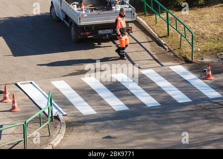 Applying road markings on asphalt using a special machine. Editorial Stock Photo