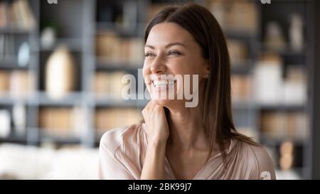 Close up smiling young woman dreaming, thinking about good future Stock Photo
