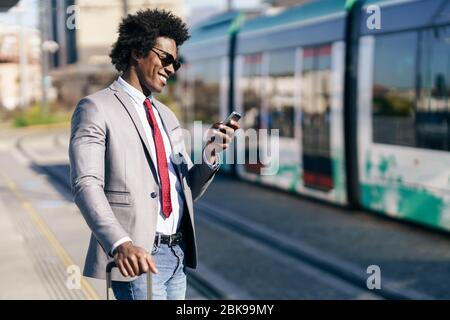 Smiling Black Businessman waiting for the next train Stock Photo