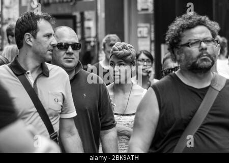 Confused looking young woman in the middle of the crowd Stock Photo