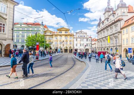 Prague, Czech Republic, May 13, 2019: people are walking crossing tram tracks on Malostranske namesti square in Prague city near Sternberg palace in Lesser Town Mala Strana district, Bohemia Stock Photo