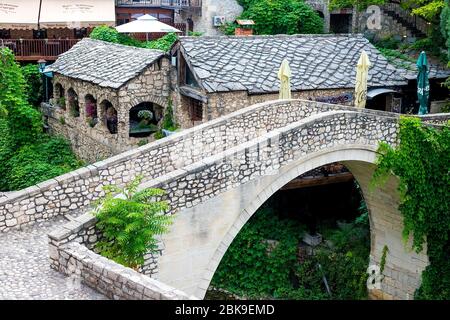 The ancient city of Mostar, Bosnia and Herzegovina. View of an alley with a river and a bridge in a small old town. Stock Photo
