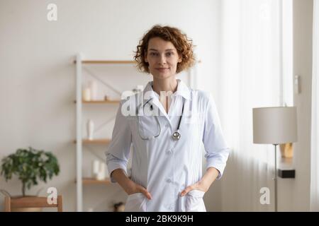 Confident young female physician standing in medical office interior, portrait Stock Photo