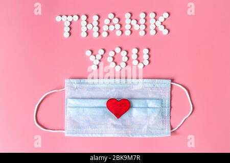 International's nurses day, week concept, Text Thank you by tablets and red heart on pink background.