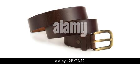A belt with a metal buckle made of brown textured leather lies coiled in several rings on a white blank background. Isolated. Stock Photo