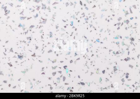 Grainy white background with gray shiny spots from foil sparkles. Texture backdrop with small crumb pattern for interior design and kitchen countertop Stock Photo
