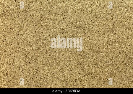 Golden sparkling background from small sequins, closeup. Yellow metallic shavings backdrop from foil. Kitchen surface countertop, macro. Stock Photo