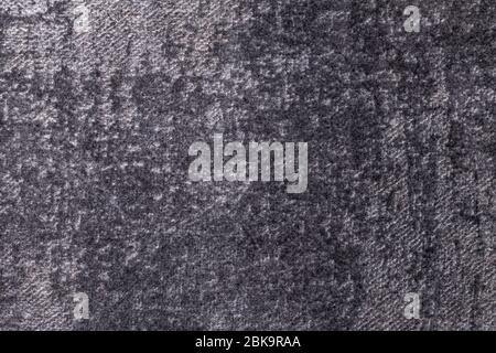 Dark gray and silver fluffy background of soft, fleecy cloth. Texture of black textile backdrop with shiny pattern, closeup. Stock Photo