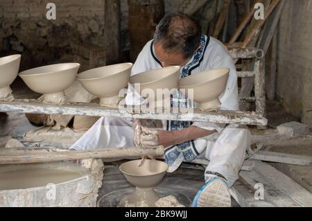 Jingdezhen, Jiangxi province / China - May 29, 2014: Porcelain Craftsman working in the Pottery workshop in Jingdezhen, China, city famous for its por Stock Photo