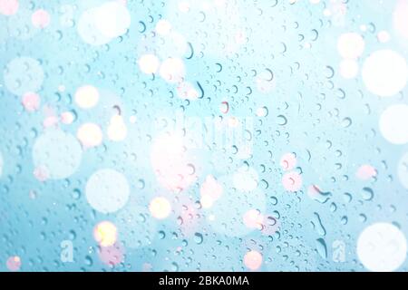 water drops on glass window with bokeh lights Stock Photo