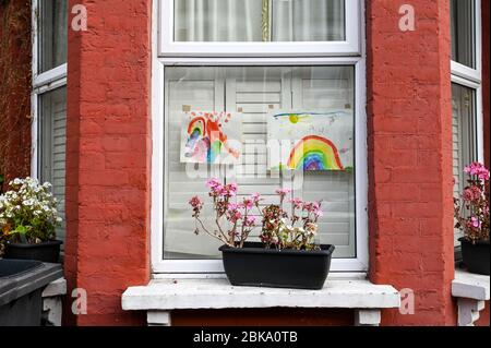 Colourful paintings of rainbows by children displayed in windows to thank the NHS and Key workers during the covid-19 pandemic. Stock Photo