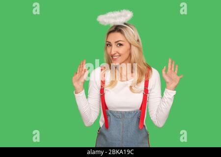 Not me! Portrait of lovely adult woman with halo above head raising hands in bewilderment, denying guilt, looking confused gesturing I don't know and Stock Photo