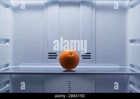 orange, lies on the shelf in the fridge Stock Photo