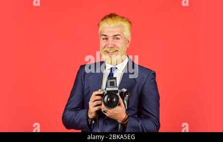Confident and handsome. professional photographer make photo. male beauty. capture result of barbershop salon. vintage camera. confident businessman hold retro camera. mature man dyed beard and hair. Stock Photo