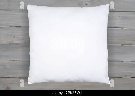 This soft white throw pillow relaxes happily on a background of rustic gray wooden planks. Plenty of room to add your own design to this square white Stock Photo