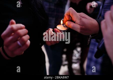 Burning candle in the hands of the newlyweds Stock Photo