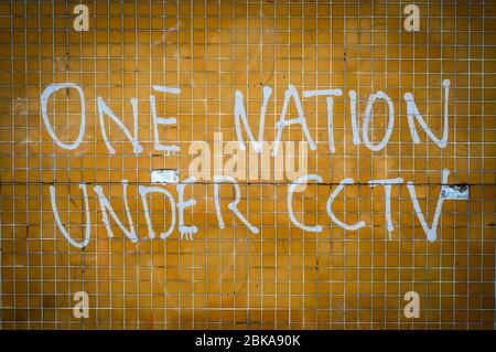 Grungy Graffiti On A Wall In The UK Saying One Nation Under CCTV Stock Photo